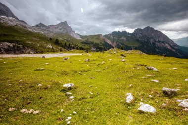 Dolomitlerde yaz zamanı. Dağlarla, bulutlarla, çayırlarla, kayalarla ve ağaçlarla dolu bir manzara..
