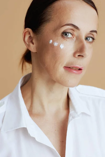 Modern Middle Aged Woman Eye Cream Face White Shirt Beige — Stock Photo, Image