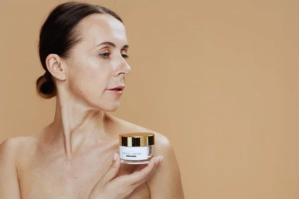 Mujer Moderna Años Con Frasco Crema Facial Sobre Fondo Beige —  Fotos de Stock