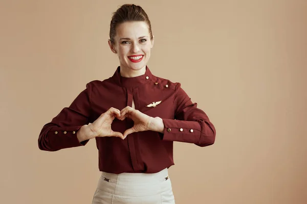 Smiling Elegant Stewardess Woman Showing Heart Shaped Hands Beige Background — Stock Photo, Image
