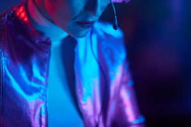 Neon metaevren fütüristik konsepti. Kulaklıklı orta yaşlı kadına yakın çekim..