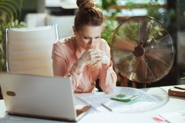 Sürdürülebilir iş yeri. Elektronik fan ve dizüstü bilgisayarlı modern iş kadını.
