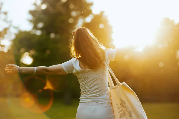 夏時間だ 自然の中で外の牧草地でトートバッグと白いシャツの幸せなスタイリッシュな女性 — ストック写真