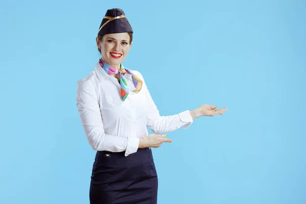 Leende Modern Kvinnlig Flygvärdinna Mot Blå Bakgrund Uniform Välkomnande — Stockfoto
