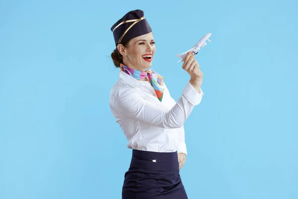 快乐的现代空姐 蓝色背景 身穿制服 有一架小飞机 — 图库照片