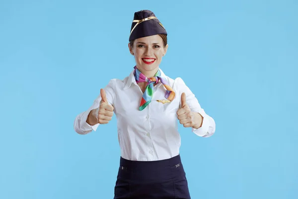 快乐的现代女乘务员 身穿蓝色背景制服 大拇指高举 与外界隔绝 — 图库照片