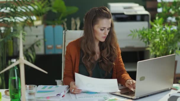 トレンディーな40歳の中小企業経営者の女性は 現代の緑のオフィスで文書を扱う — ストック動画