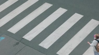 Beyaz kazaklı, sırt çantalı, yaya geçidinden geçen ve şehir dışındaki okula giden son moda öğrencinin manzarası..