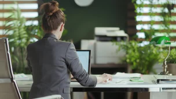 可持续工作场所 从现代小企业主的背后看身着灰色西装 手牵手进入现代绿色办公室的女人 — 图库视频影像