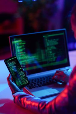 Modern ofiste dizüstü bilgisayarı ve akıllı telefon geliştirme programı olan modern bir kadın tarafından görüldü..