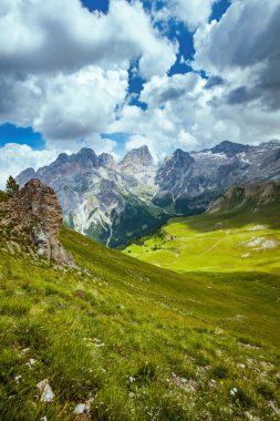 Dolomitlerde yaz zamanı. Dağlı, tepeli, bulutlu ve otlu manzara.