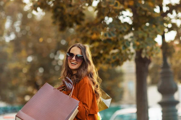 10月份 城市里穿着棕色风衣 头戴购物袋的优雅优雅女性 — 图库照片