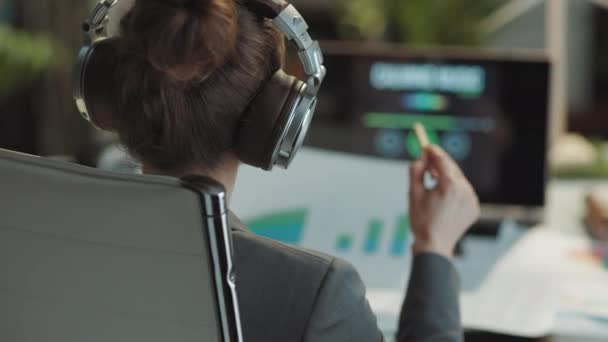 Modern Bir Kadınının Arkasında Belgeli Dizüstü Bilgisayarlı Modern Ofiste Kulaklıkla — Stok video