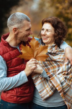 Merhaba sonbahar. Parkta sonbahar yaprağıyla mutlu romantik sevgili.