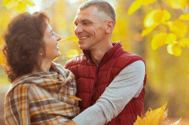 Merhaba sonbahar. Güler yüzlü şık aile parkta sarılıyor..