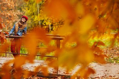 Merhaba sonbahar. Kırk yaşında, kot gömlekli, kırmızı şapkalı, güz yapraklı ve fularlı zarif bir kadın..