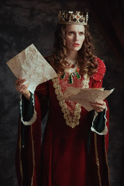 不幸的中世纪女王 身穿红衣服 头戴羊皮纸 头戴深灰色背景的皇冠 — 图库照片