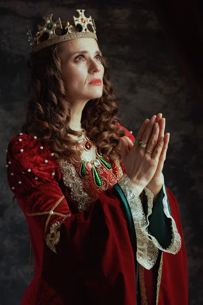 Średniowieczna Królowa Czerwonej Sukience Koroną Modląca Się Ciemnoszarym Tle — Zdjęcie stockowe