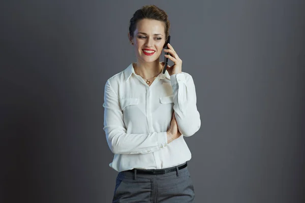 穿着白衬衫的快乐时髦的商界女性 使用灰色背景的智能手机 — 图库照片