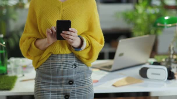 スマートフォンを使用して緑のオフィスで黄色のセーターの中小企業の所有者の女性の閉鎖 — ストック動画
