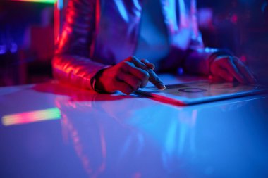 Neon metaevren fütüristik konsepti. Ofiste tabletli bir kadına yakın çekim..