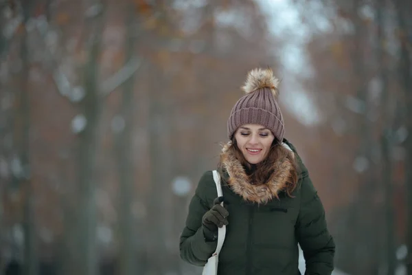 幸せな現代中年女性 緑のコートと冬の街公園の屋外の茶色の帽子とビーニーの帽子 — ストック写真