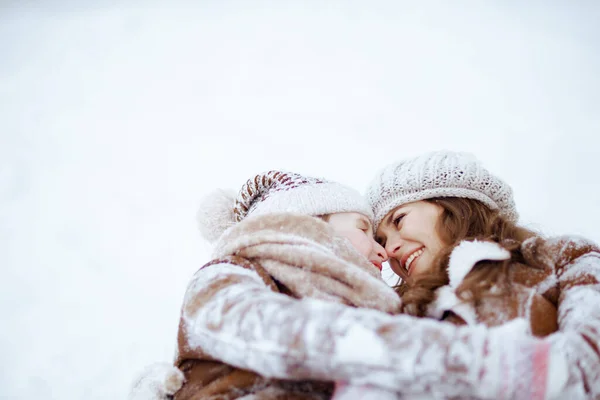 冬日里 穿着外套 围巾和手套的时髦妈妈和女儿躺在城市公园的室外雪地里 — 图库照片