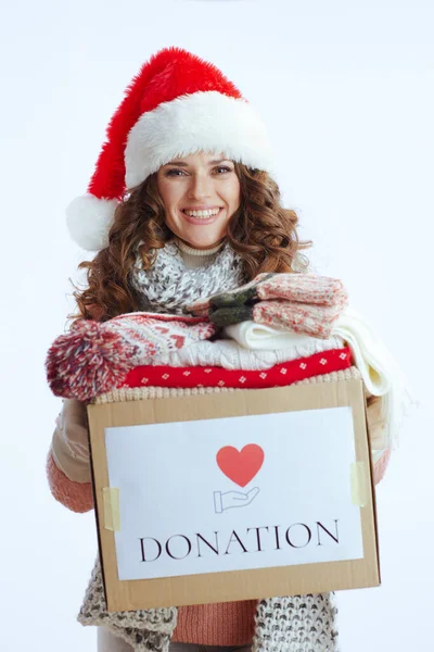 Hello winter. happy stylish female in sweater, mittens, hat and scarf with santa hat and donation box isolated on white.