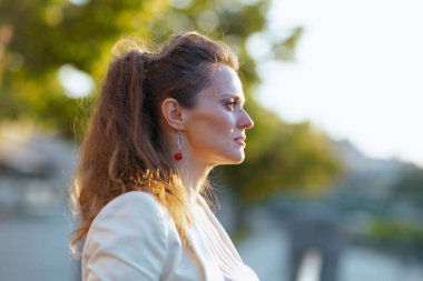 Pembe elbiseli, beyaz ceketli, modaya uygun bir kadın....