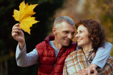 Merhaba sonbahar. Parkta sonbahar yapraklı mutlu bir çift..