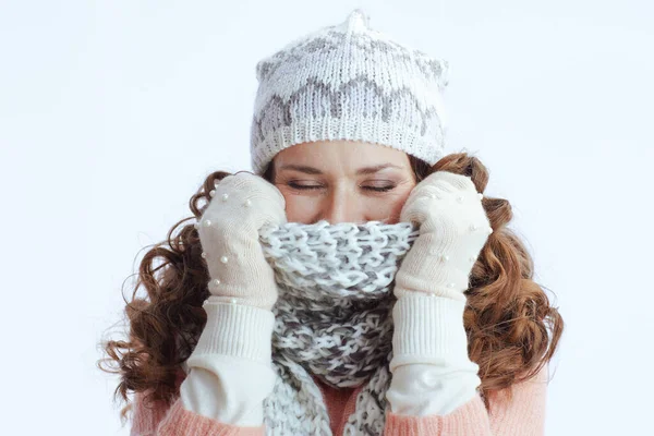 Hello winter. modern woman in sweater, mittens, hat and scarf isolated on white background wrapping up in a scarf.