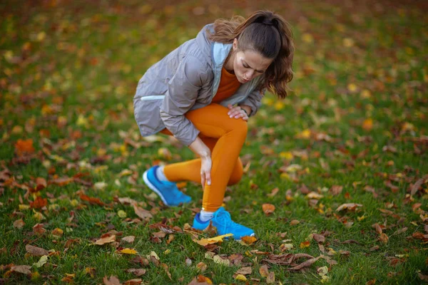 Merhaba Sonbahar Parktaki Spor Kıyafetleri Içinde Bacağı Ağrıyan Üzgün Bir — Stok fotoğraf