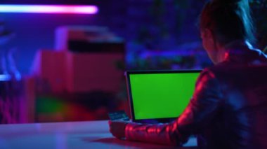 Seen from behind modern woman with laptop blank screen in modern office.