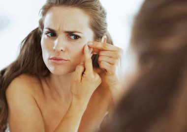 hayal kırıklığına uğramış genç kadın sivilce sıkma