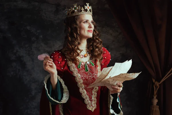 快乐的中世纪女王 身穿红色衣服 头戴羊皮纸 头戴深灰色背景的皇冠 — 图库照片