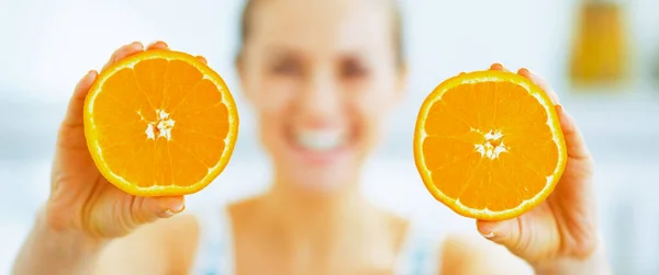Closeup on slices of orange in hand of young woman