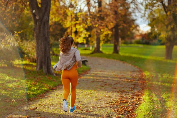 Merhaba Sonbahar Parkta Koşan Spor Elbiseli Bir Kadının Arkasından Görülmüş — Stok fotoğraf