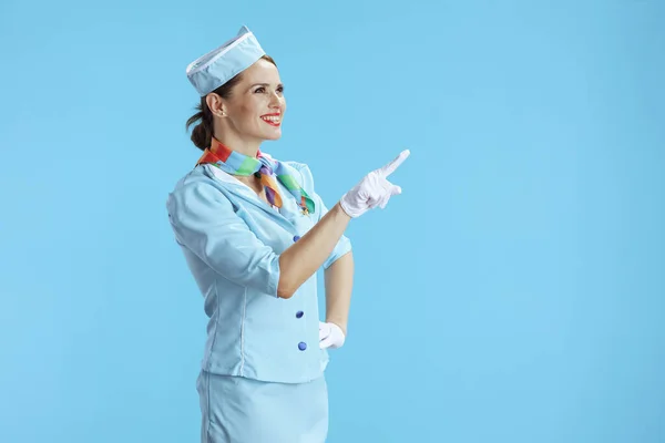 Χαμογελαστή Κομψή Γυναίκα Αεροσυνοδός Μπλε Φόντο Μπλε Στολή Δείχνοντας Κάτι — Φωτογραφία Αρχείου