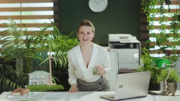 移動する時間です 笑顔のエレガントな女性不動産エージェント キーで白いブラウスの現代緑のオフィスで — ストック動画