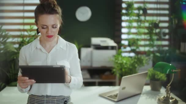 エコ不動産事業について デジタル タブレットおよびキーが付いている白いブラウスの現代緑のオフィスの幸せなスタイリッシュな中年の女性のリアクター — ストック動画