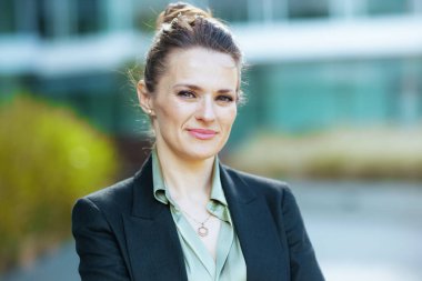 Hüzünlü modern 40 yıllık kadın portresi ofis binası yakınında siyah ceketli..