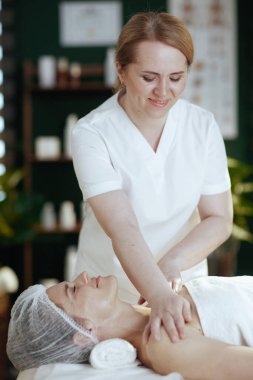 Sağlık hizmeti zamanı. Spa salonunda masaj terapisti müşterilerin omuzlarına masaj yapıyor..