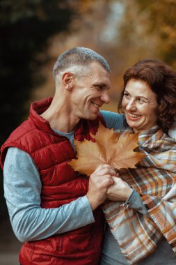 Merhaba sonbahar. Parkta sonbahar yaprağıyla mutlu romantik sevgili.