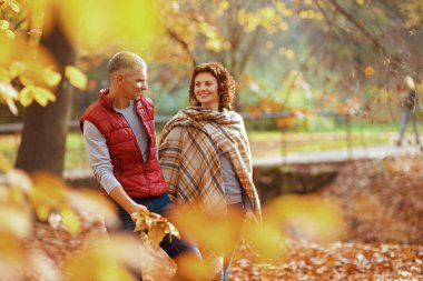 Merhaba sonbahar. Parkta sonbahar yapraklarıyla yürüyen mutlu şık bir çift..
