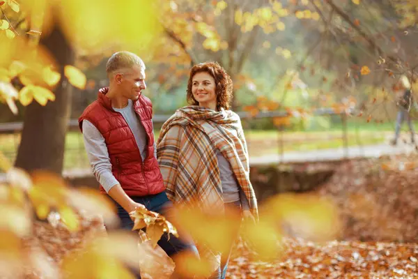 Merhaba sonbahar. Parkta sonbahar yapraklarıyla yürüyen mutlu şık bir çift..