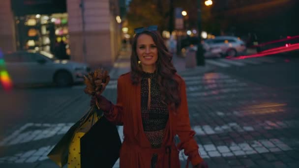 Turuncu Trençkotlu Alışveriş Çantalı Sonbahar Sarısı Yapraklı Mutlu Bir Kadın — Stok video