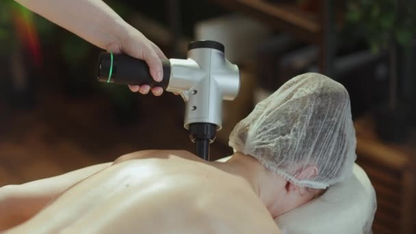 Gesundheitszeit Massagetherapeut Wellness Salon Mit Massagepistole Massiert Kunden Den Nacken — Stockvideo