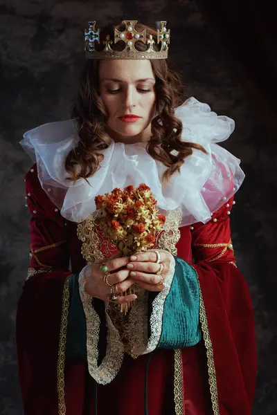 中古时代的女王 身穿红色衣服 花朵干枯 头戴深灰色背景的皇冠 — 图库照片