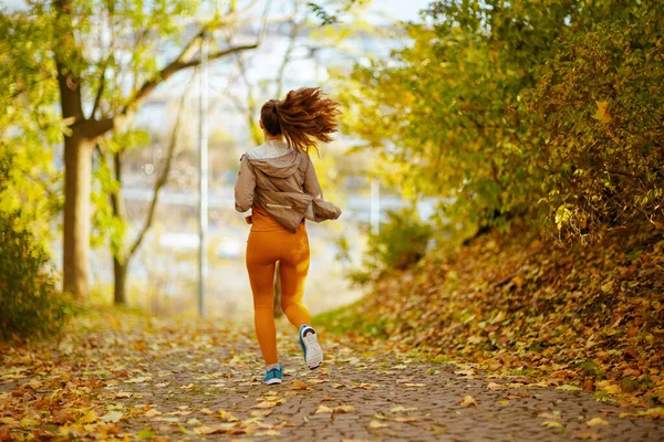 Merhaba Sonbahar Parkta Koşan Spor Elbiseli Bir Kadının Arkasından Görülmüş — Stok fotoğraf