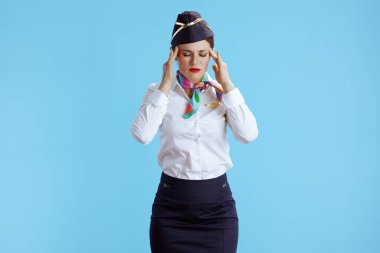 Stresli havalı hostes kadın üniformalı mavi arka plana karşı.